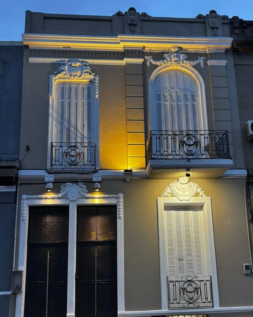 Fachada reciclada del edificio de Espacio 1010, iluminada de noche, una casa de principios de siglo XX entre Palermo y Parque Rodó